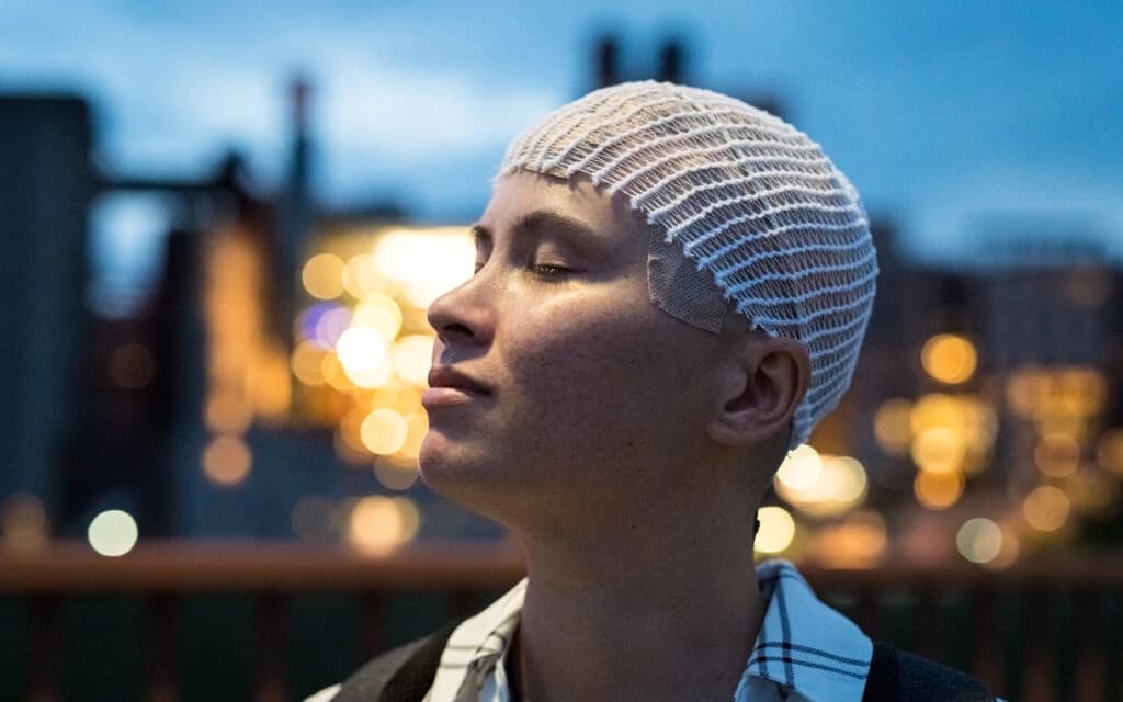 Portrait of Jovan, a confident professional with crossed arms wearing a dark blazer and blue shirt