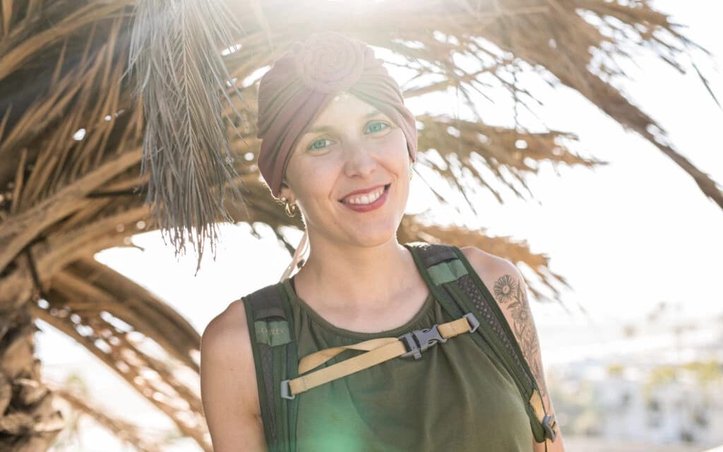 Professional portrait of Janice, a confident woman with curly hair smiling in a modern office environment